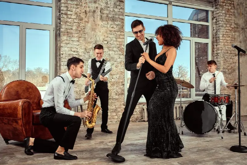 Quintette de jazz dans un loft en briques : saxophoniste, guitariste, deux chanteurs au micro et batteur