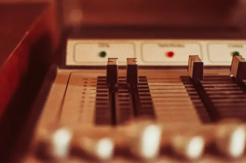 Curseurs d'une ancienne table de mixage analogique, en gros plan
