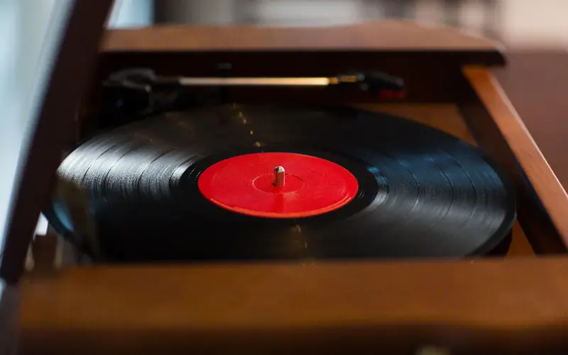 Disque vinyle à étiquette rouge sur une platine en bois